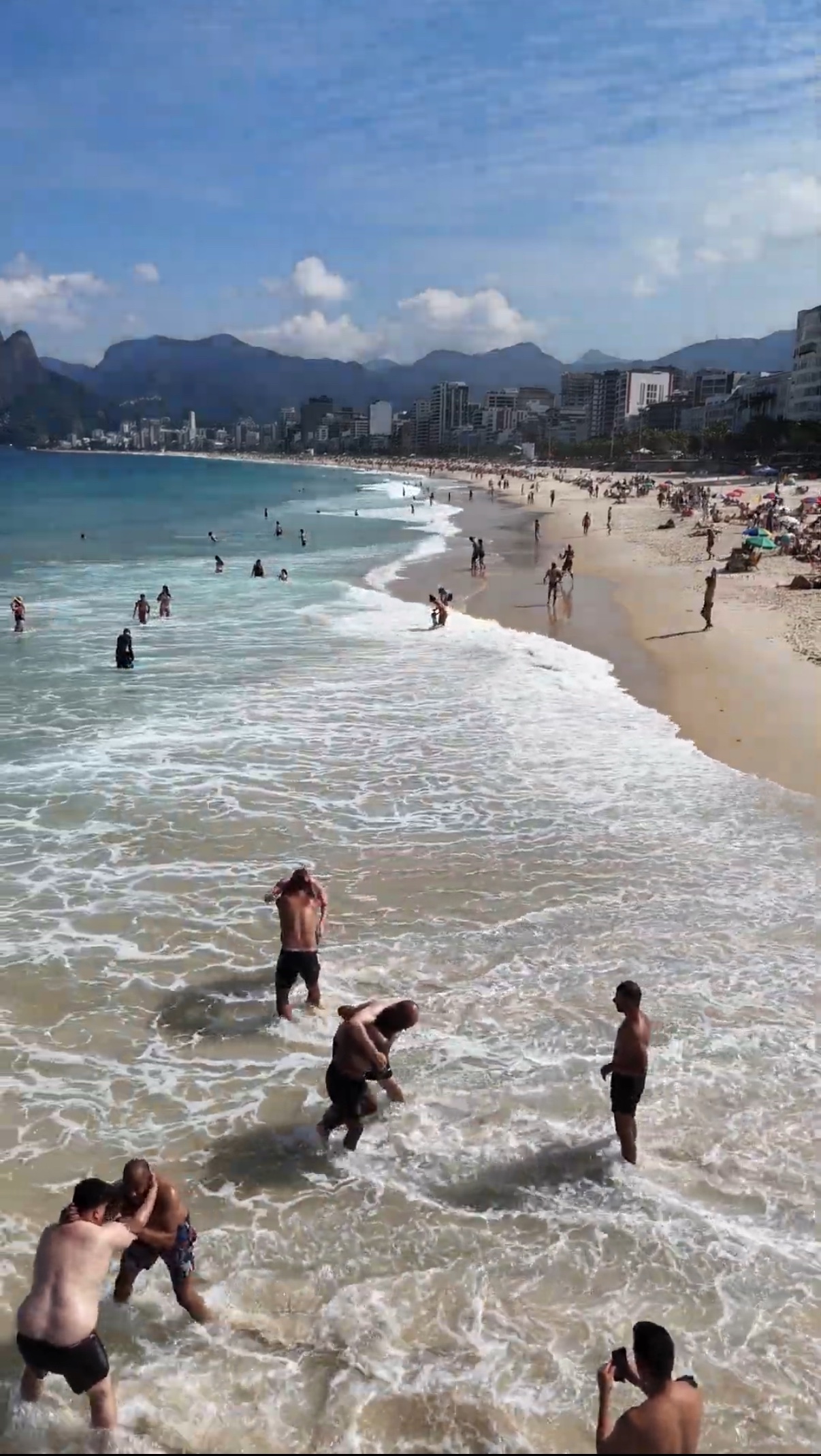 OSS Rio Tour travelers grappling in the surf at Arpoador beach, Rio de Janeiro