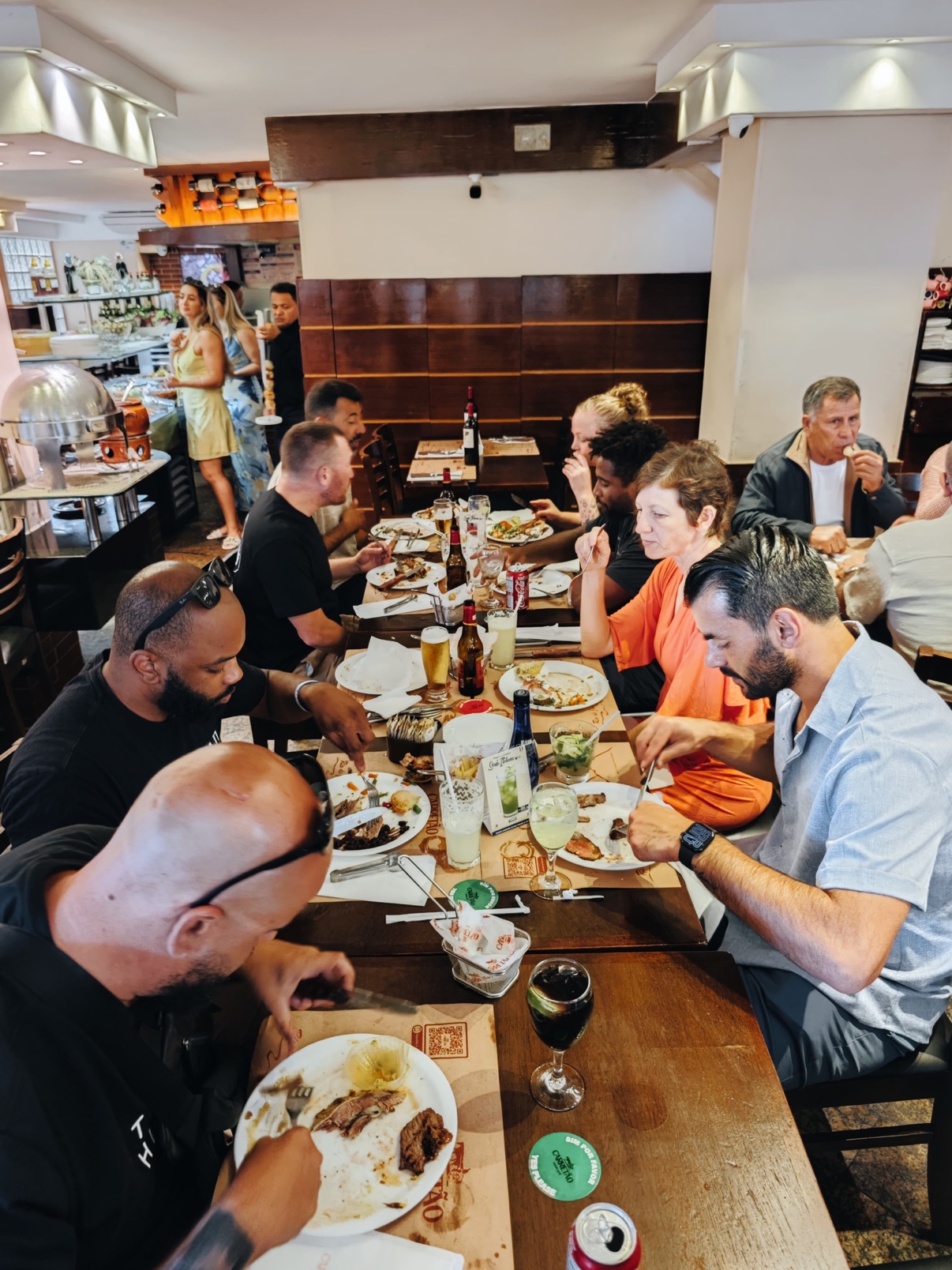 OSS Rio Tour travelers at a rodízio table in a Brazilian churrascaria