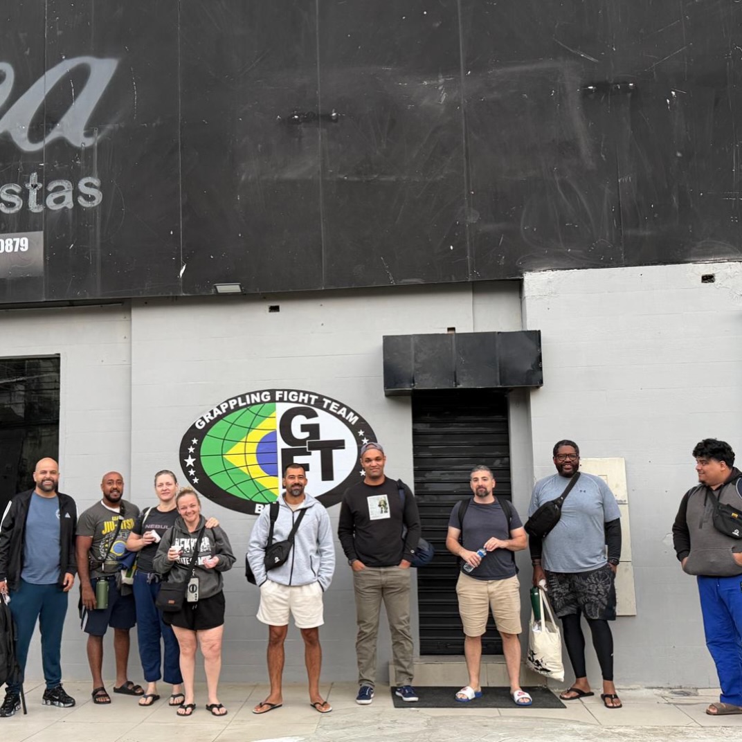 OSS Rio Tour group in front of the GFTeam logo wall