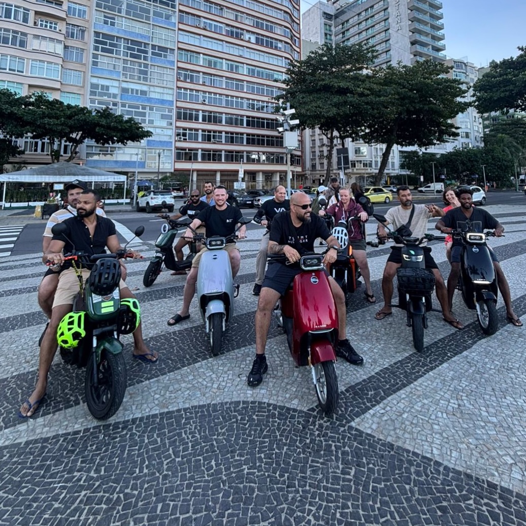 OSS Rio Tour crew riding scooters along the Copacabana promenade